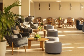 A spacious lobby with multiple seating areas, including sofas and ottomans, arranged around tables. - Valmar Corfu (Corfu)