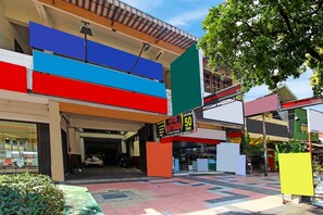 Un hotel con fachada colorida, un cartel que indica un precio de 50, y una entrada cubierta.
