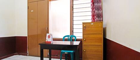 A small room with a wooden cabinet, a table, and a chair.
