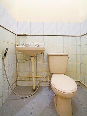 Un baño pequeño y sencillo con inodoro y lavamanos.