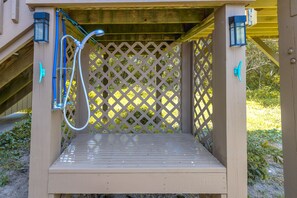 A wooden deck with a metal bench, a lattice fence, and a hose. - Sol Mate - 5BR 2nd Row Home with Ocean Views, Pool, Hot Tub & Pet Friendly! (North Topsail Beach)