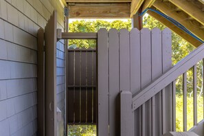 A wooden gate leading to a covered outdoor area with a view of trees. - Sol Mate - 5BR 2nd Row Home with Ocean Views, Pool, Hot Tub & Pet Friendly! (North Topsail Beach)