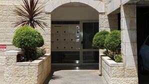 Un bâtiment en pierre doté d’une entrée en arc de cercle, d’une enseigne indiquant le numéro 18 et d’un espace de stationnement où se trouve une voiture.