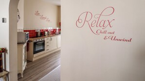 Una cocina con salpicadero de azulejos rojos y blancos, un microondas y una estufa.