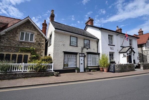 A traditional pub with a stone facade, a white exterior, and a flag.