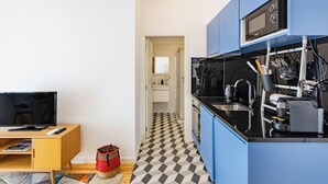 Une cuisine moderne avec des meubles bleus, un four à micro-ondes et une machine à café.