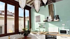 Una cocina con ventana, pileta, microondas y estufa.