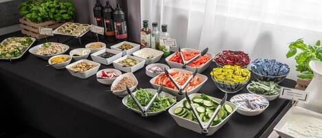 Uma mesa de buffet com diversos alimentos e acompanhamentos.