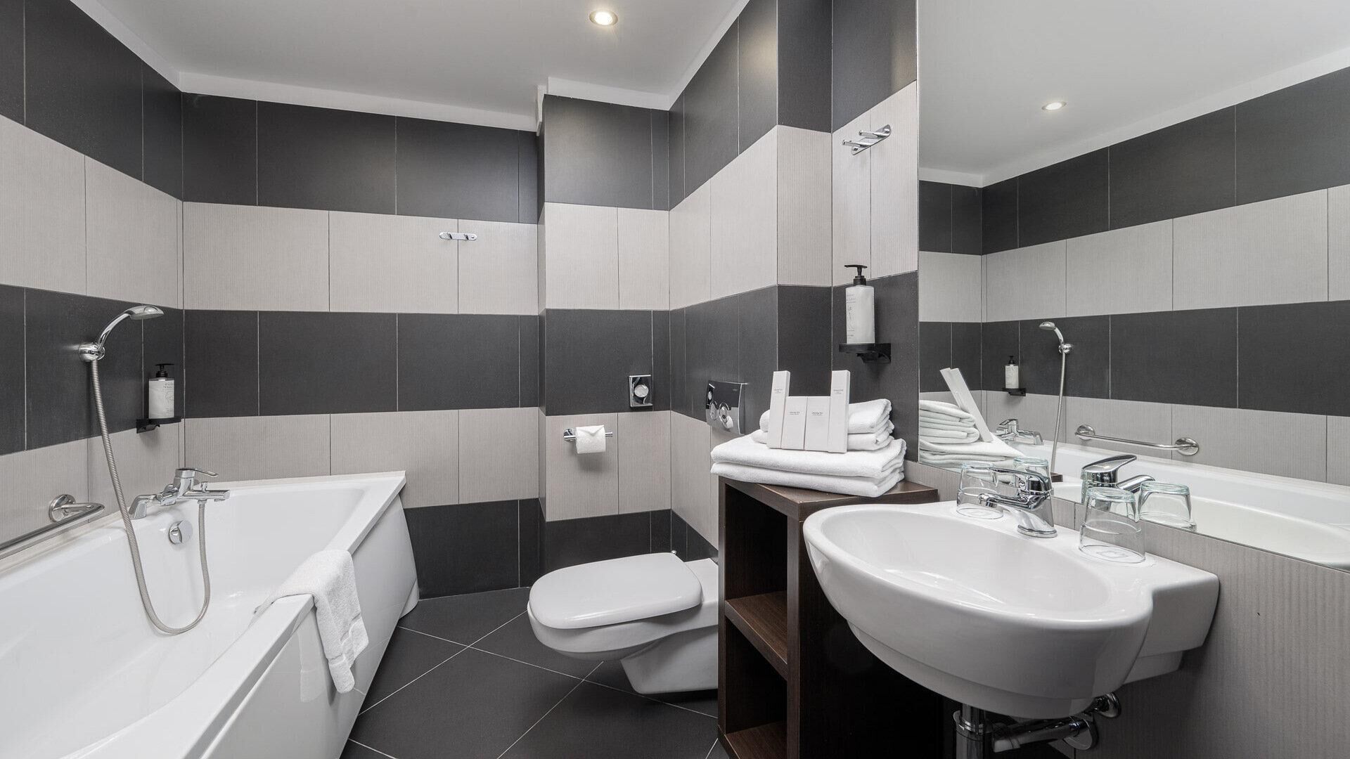 A modern bathroom with a bathtub, toilet, and sink.