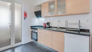 A modern kitchen with a dishwasher, stove, and sink. - Alta Garajau I (Caniço)