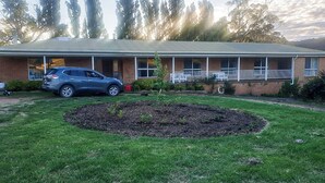A building with a brick facade, a covered porch with white railings, and a car parked in front. - Guest Suite Bredbo (Jerangle)