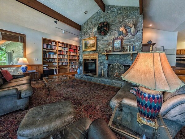 A cozy living room with a fireplace, bookshelves, and comfortable seating.