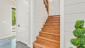 Eine Holztreppe mit weißen Wänden und einem Holengeländer.