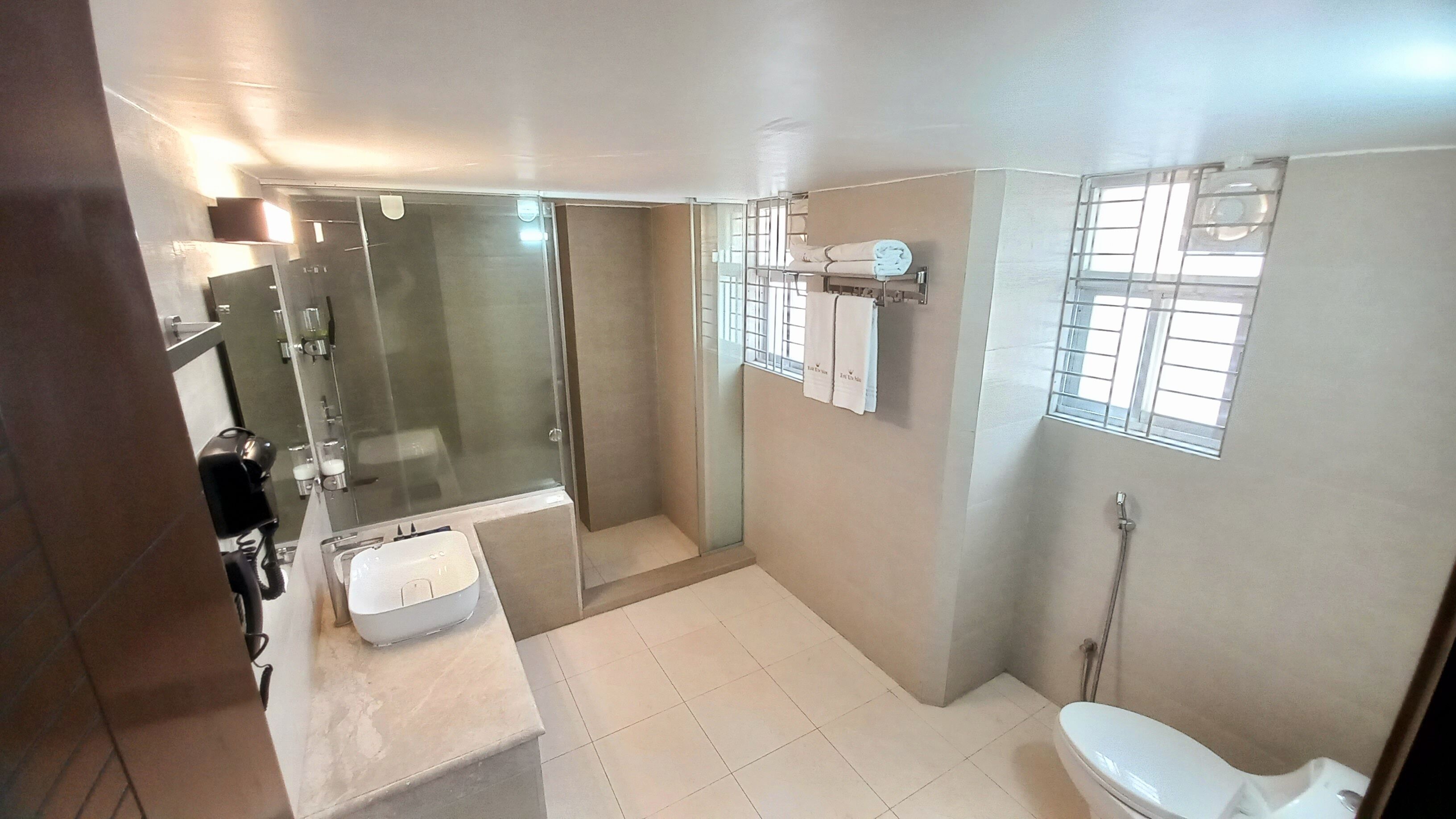 A modern bathroom with a glass shower enclosure, a white sink, and a toilet.