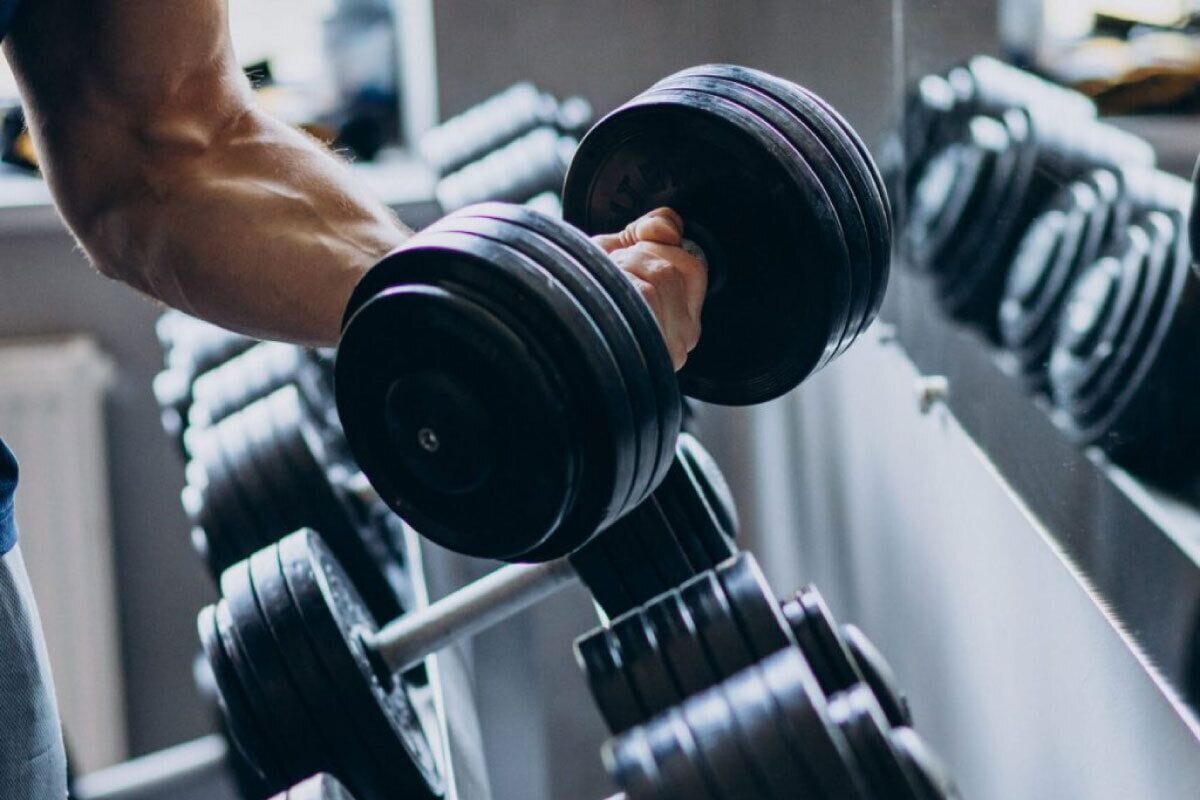 A close-up of a person's arm lifting a dumbbell.