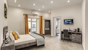 Una habitación de hotel moderna con cama, escritorio y televisor.