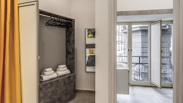 Un baño moderno con tocador de mármol gris, un perchero y un espejo.