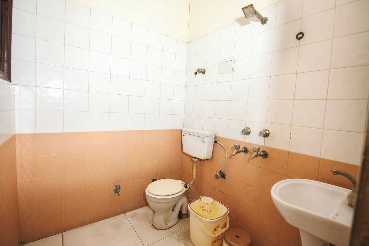 A small bathroom with a toilet, sink, and shower.