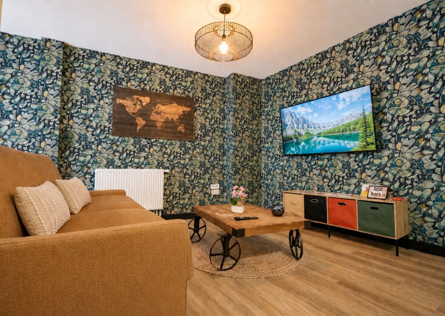 A living room with a sofa, a coffee table, a TV, a world map, and a cabinet.