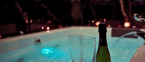 Un jacuzzi con dos copas y una botella de champán.