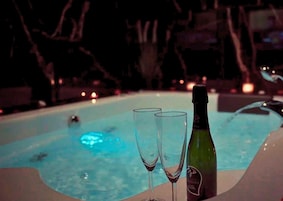 Un jacuzzi con dos copas y una botella de champán.