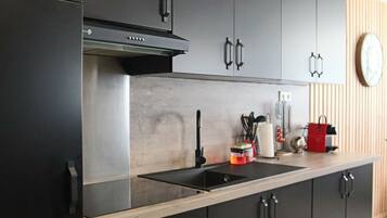 Deluxe appartement | Privékeuken | Een koelkast met diepvriezer, een microgolfoven, een kookplaat