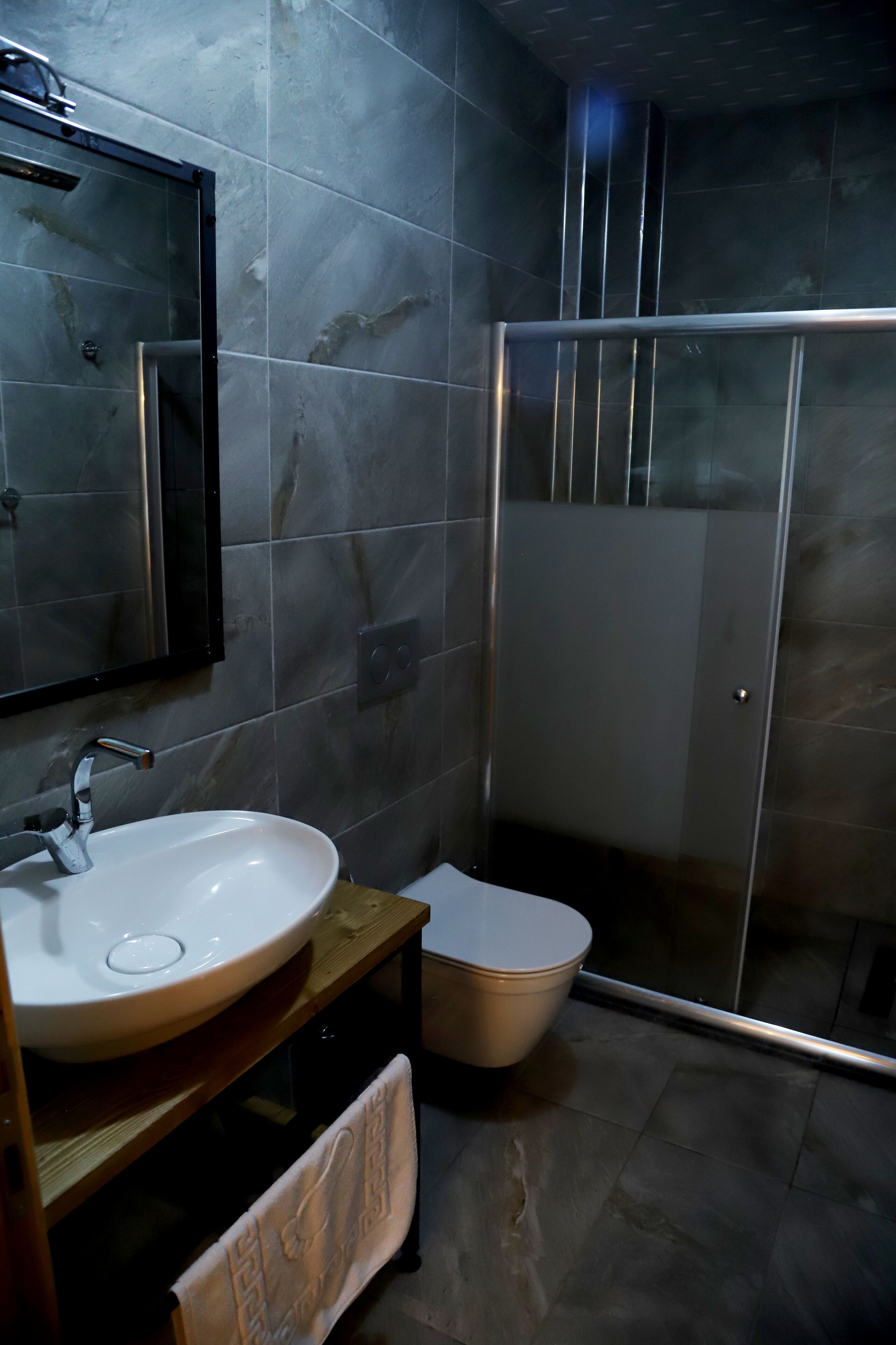 Ein Badezimmer mit Waschbecken, Toilette und einer Duschkabine aus Glas.