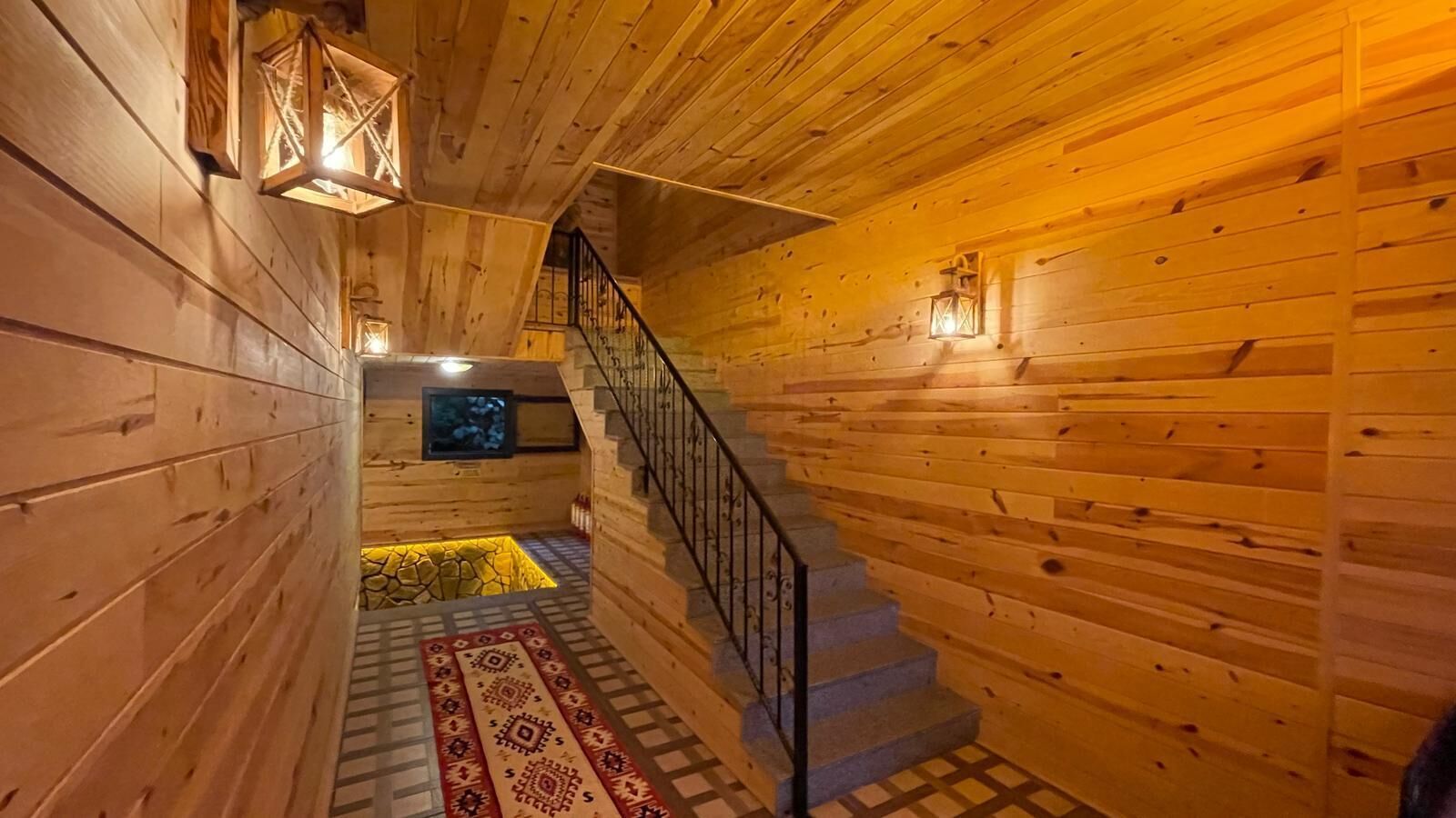 A wooden interior with a staircase leading to a lower level.