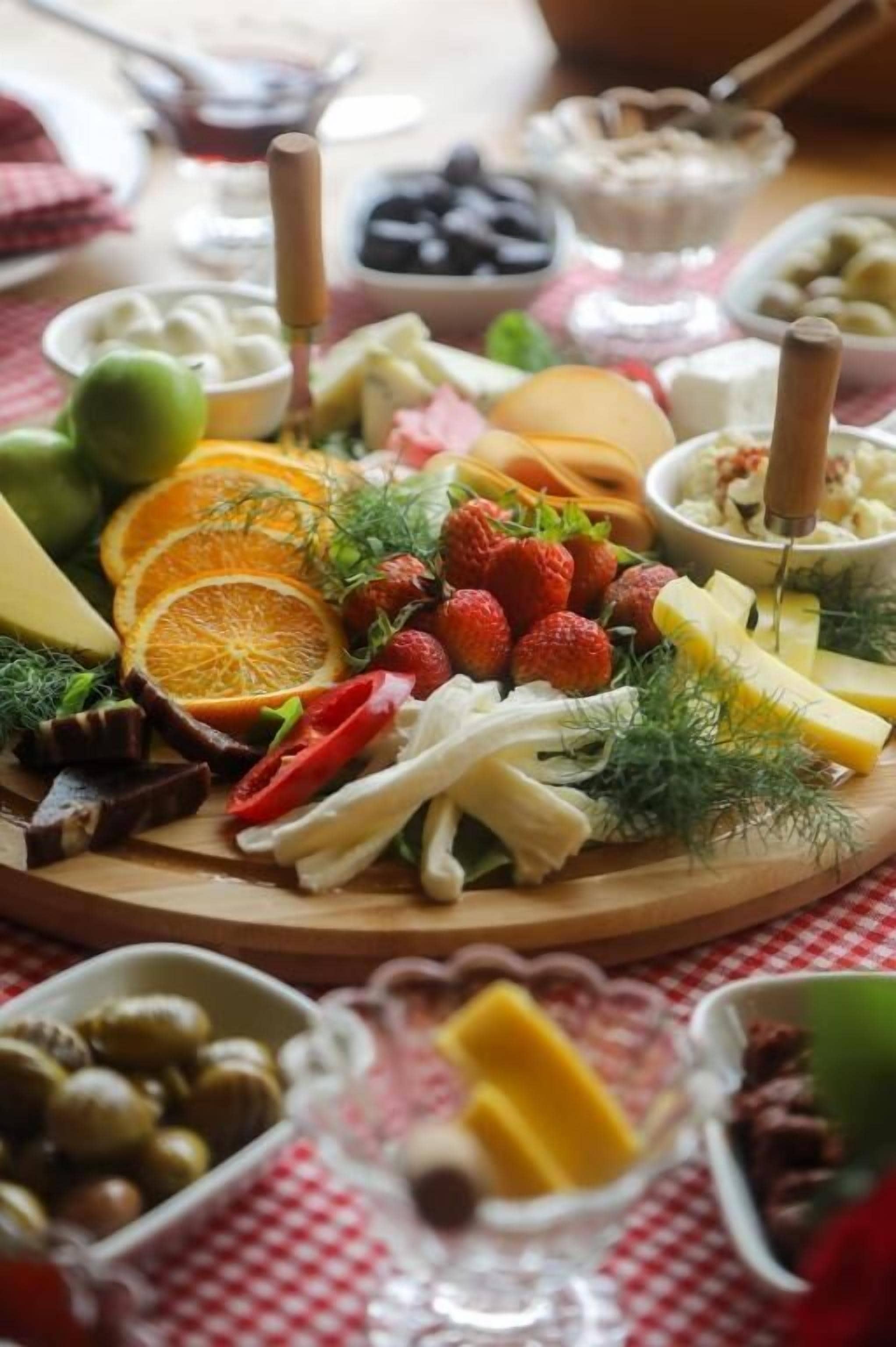 A charcuterie board with various cheeses, fruits, and nuts.