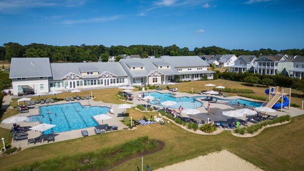 A large resort with multiple swimming pools, sun loungers, and a beach area. - Bayfront Home Featuring Private Beach Access in Bay Creek! (Cape Charles)
