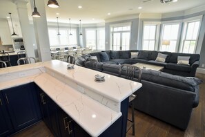 Enjoy a spacious kitchen and living area with a sleek design, featuring a sink and cozy seating.