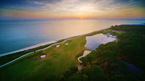 Enjoy a round of golf surrounded by a serene coastal landscape and a tranquil body of water.