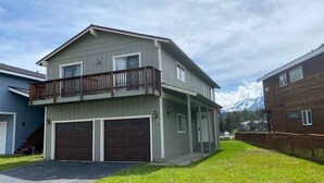 A two-story residential building with a balcony, two garages, and a well-maintained lawn. - 584 Alpine Drive in South Lake Tahoe, CA (South Lake Tahoe)
