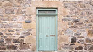 A stone building with a light blue door, a number plaque above the door, and a sign that reads "SEASPRAY" on the wall. - Pretty cottage on Moray coast: walks & whisky (Buckie)