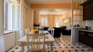 Un comedor con mesa y sillas, una cocina con armarios y una sala de estar con sofá.
