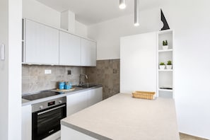 A modern kitchen with white cabinets, a built-in oven, a sink, and a countertop. - Casa Andreale, Capoliveri, Centro (Capoliveri)