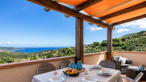 Mesa para cuatro con vista al mar y las colinas.