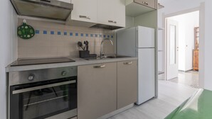 Una cucina moderna con elettrodomestici in acciaio inossidabile, forno integrato e lavello.