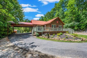 A log cabin with a porch, surrounded by a forest. - Romantic hot tub cabin | Secluded (Cosby)