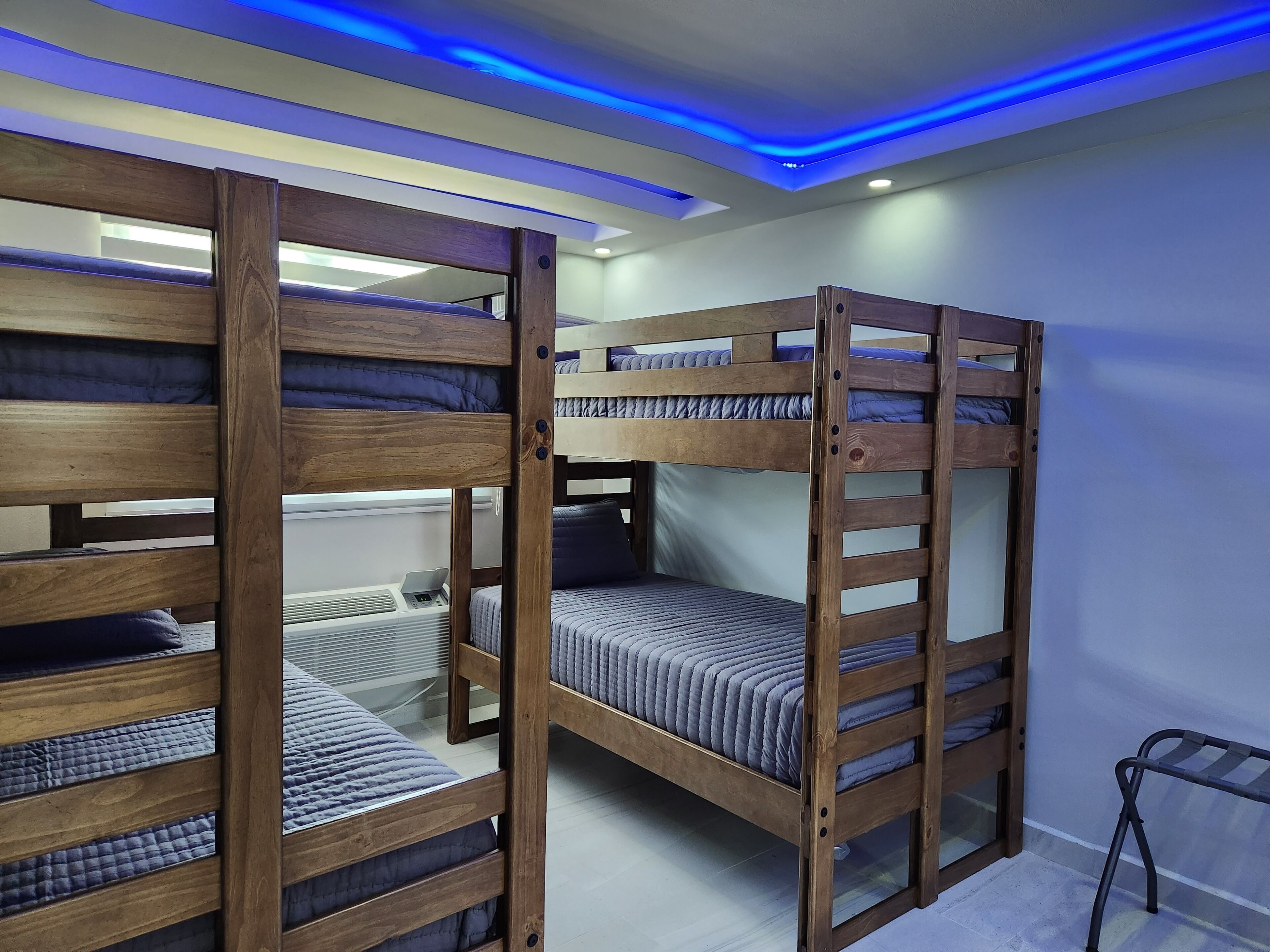 A bunk bed room with wooden frames and blue bedding.