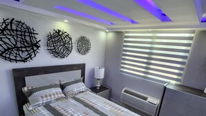 A modern bedroom with a large bed, a desk, and a chair. - Aquatika Minimalist Beach Escape (Loiza)