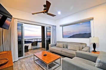 The sitting area offers comfortable sofas, a coffee table, and a wall-mounted TV