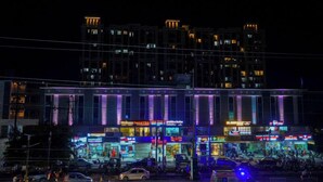 A multi-story building with illuminated signage, including a dental clinic. - Zip By Spree Hotels Bhopal (Bhopal)