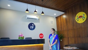 A reception area with a wooden ceiling, a reception desk, a wall-mounted air conditioner, and a 'ZIP' sign. - Zip By Spree Hotels Bhopal (Bhopal)