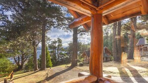 A wooden cabin with a view of a lake and surrounding trees. - Villa Labrador Bariloche (San Carlos de Bariloche)