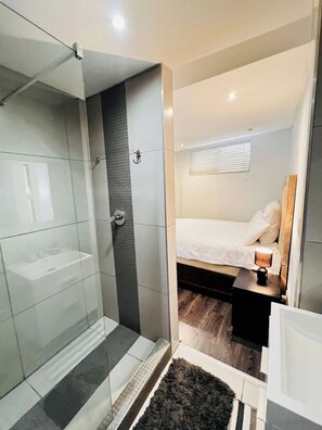 Cozy retreat with a single bed, bedside table, and modern shower area.