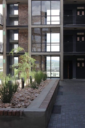 Stunning multi-story building with large windows and a beautifully landscaped area.