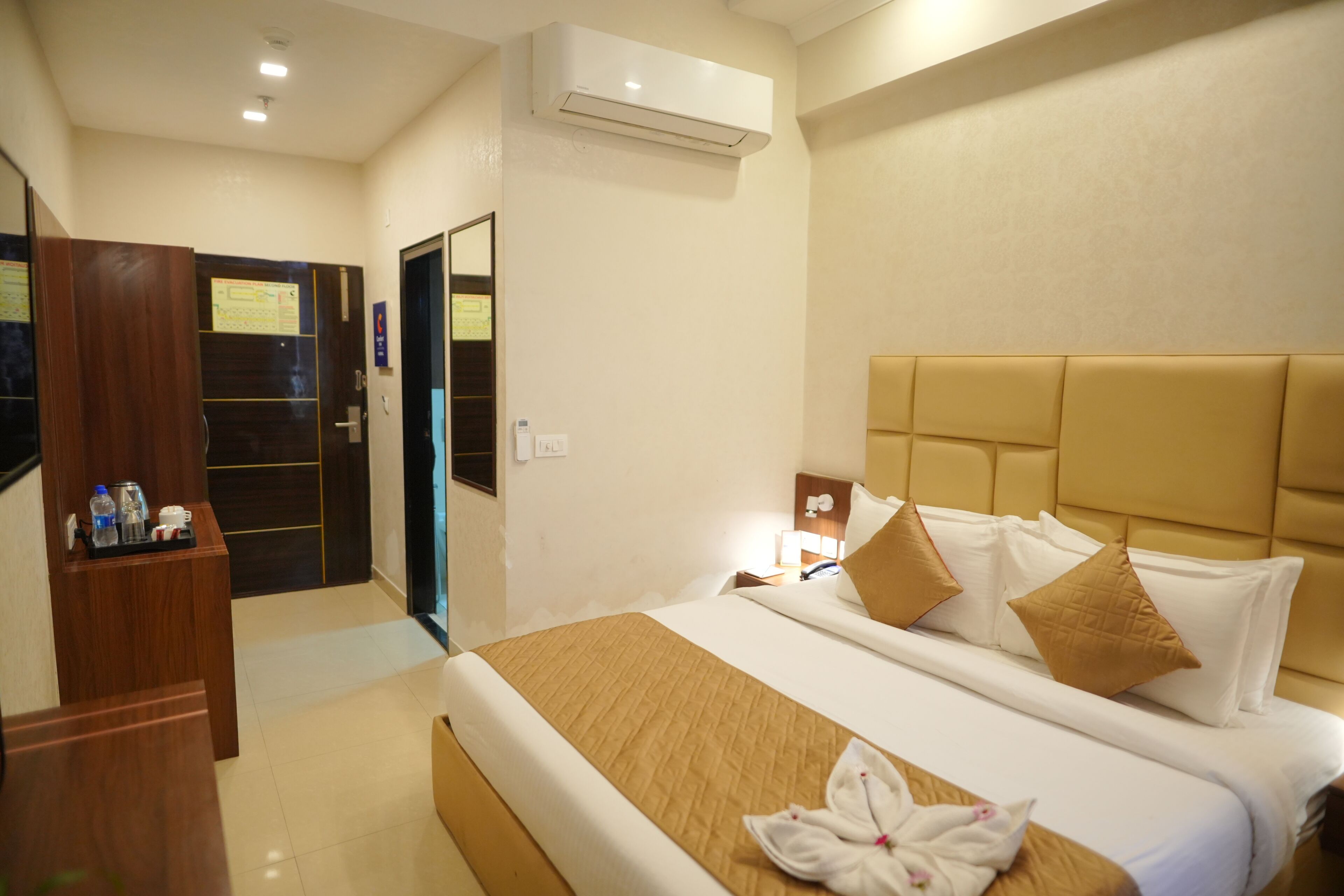 Una habitación de hotel con cama, escritorio y aire acondicionado.