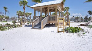 Een houten constructie aan het strand met een trap en een bordje dat aangeeft dat het privé-eigendom is.