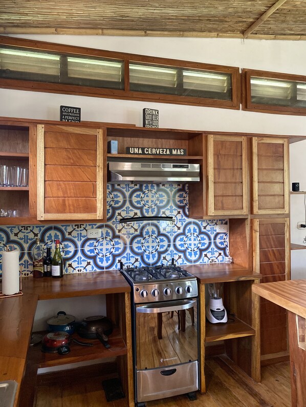 Een magnetron, een oven, een koffiezetapparaat/waterkoker, keukeneiland